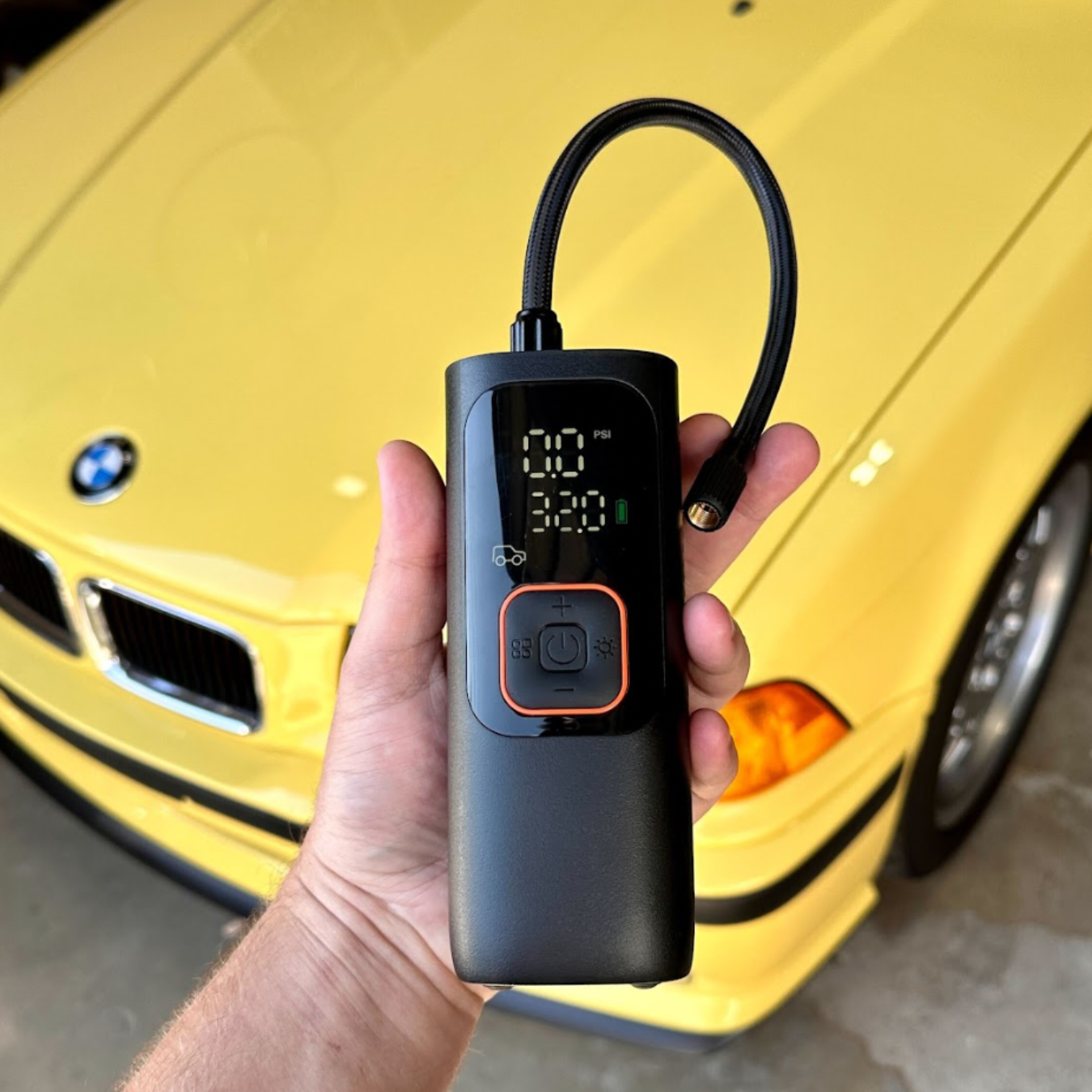 Image of the Bavsound Air Pump in front of a yellow BMW.